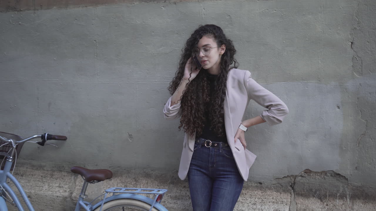 Young Woman Talking on Phone near a Bike