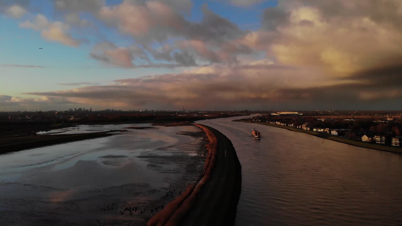 barco de carga navegando en el río noord pasando por natuureiland sophiapolder en hendrik-ido-ambacht, países bajos al atardecer