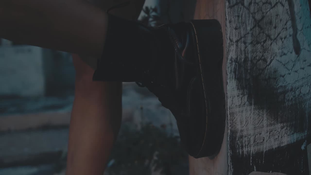 Woman's legs and black platform boots on a graffiti wall