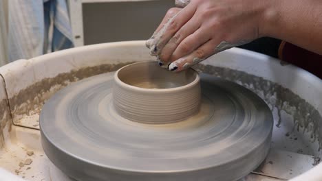 young woman in pottery studio using pottery wheel, handmade ceramics, creative