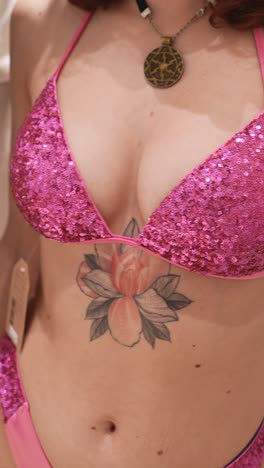 woman in pink sequined bikini with tattoos