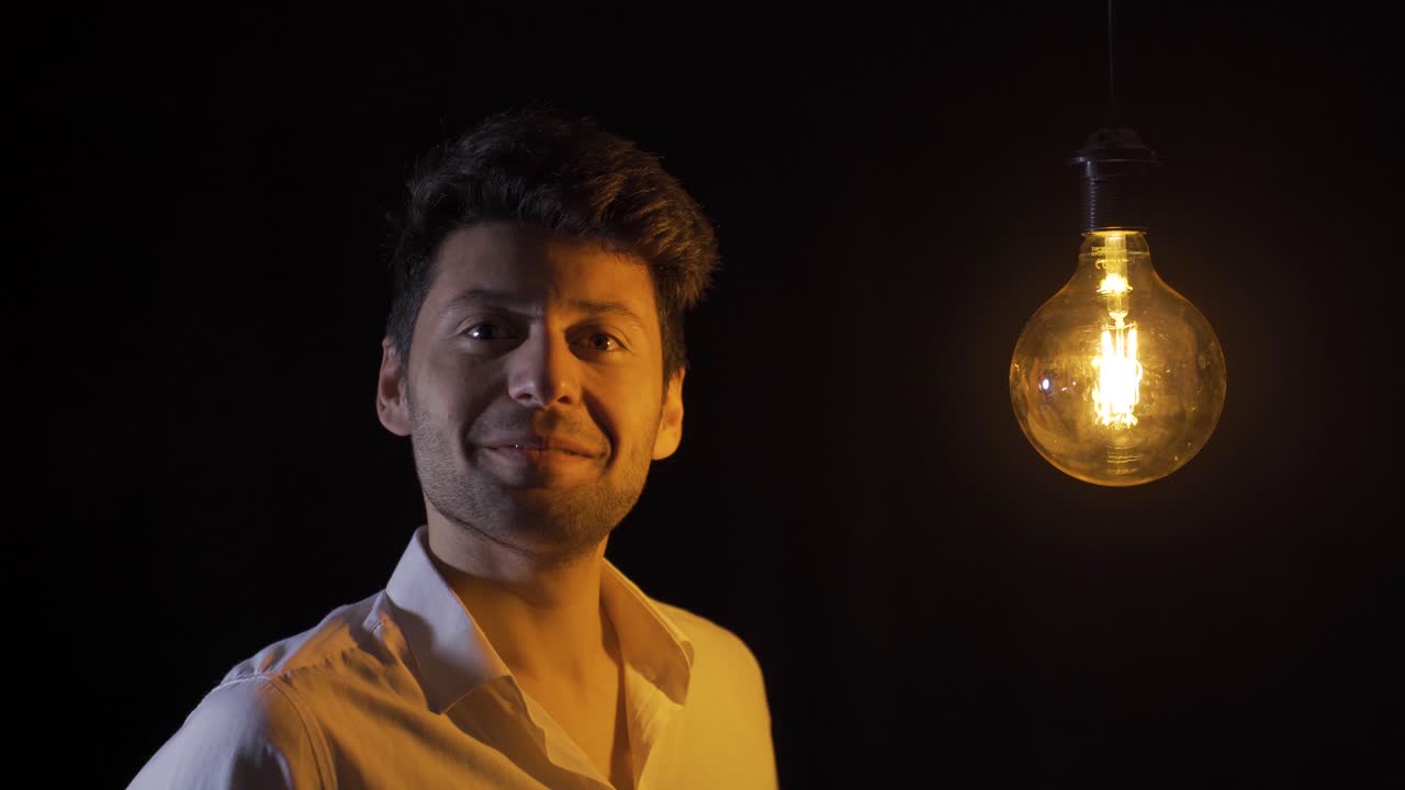 cuando el hombre chasquea el dedo, la lámpara se enciende, lo que significa que tiene una idea.