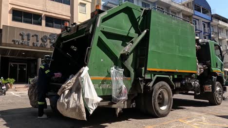 workers loading trash into a garbage truck