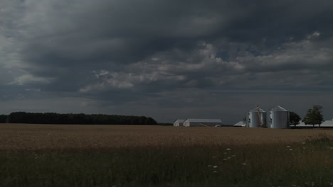 big sky over ontario farmland with farm and grain silos in the distance