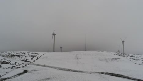 winter mountain countryside wind turbines on rural highlands aerial view cold blizzard valley hillside rising