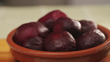 raw peeled vegetable beet in plate on wooden table close-up. preparing raw vagetables food for cooking. cooking traditional russian borsch.
