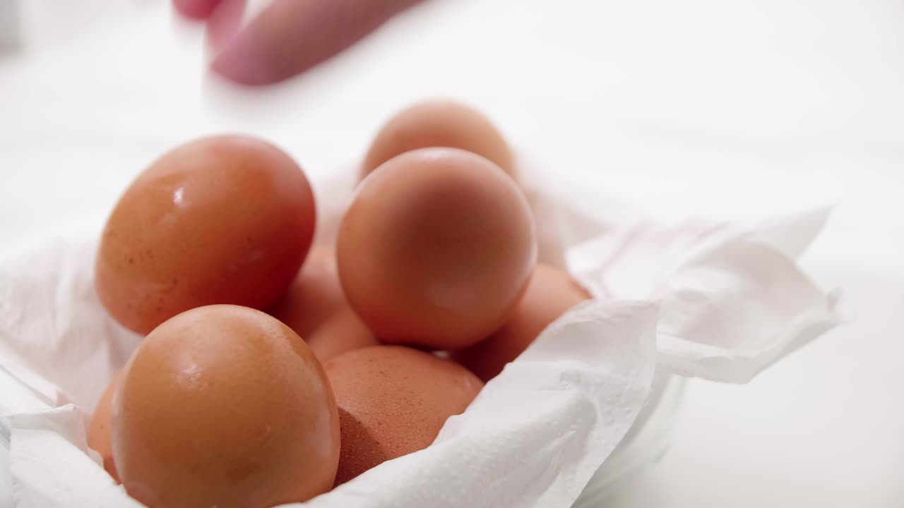 Close up male hand taking brown eggs out of the carton