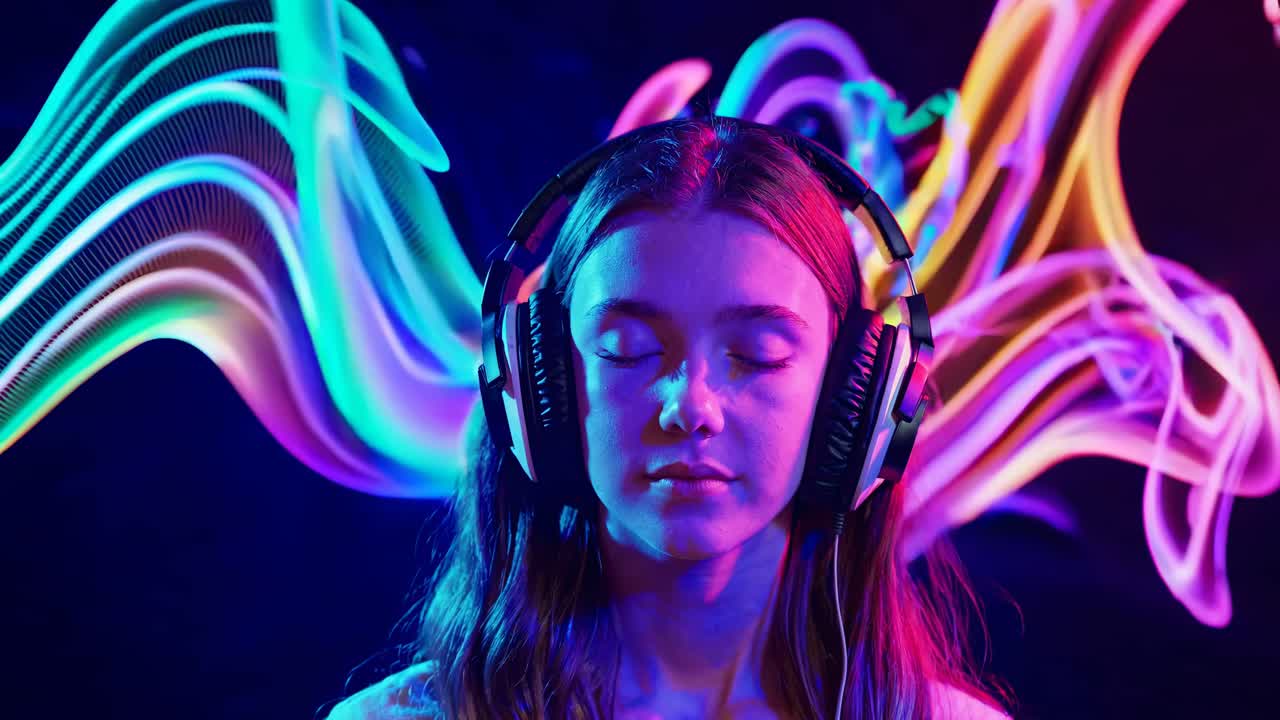 una adolescente escuchando música con una pintura de luz colorida