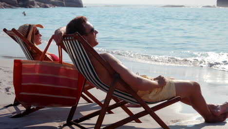 Linda-Pareja-Relajándose-En-Una-Silla-De-Playa-