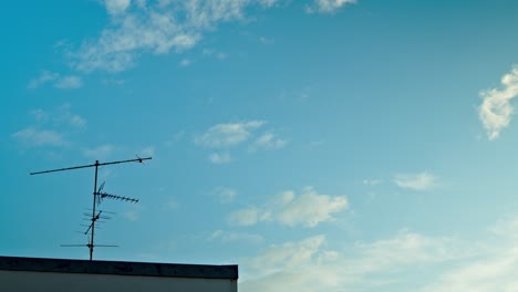 Lapso-De-Tiempo-De-Antenas-De-Estilo-Antiguo-En-La-Parte-Superior-De-Un-Edificio-Y-Nubes-En-El-Fondo