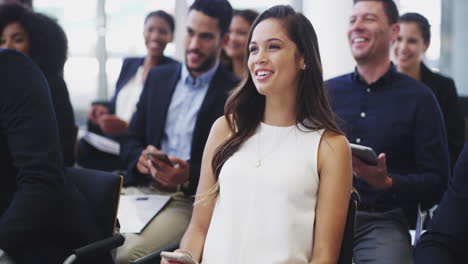 una joven empresaria sentada en una conferencia