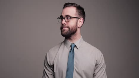 awkward man looks up and anxiously cleans glasses with tie, medium shot