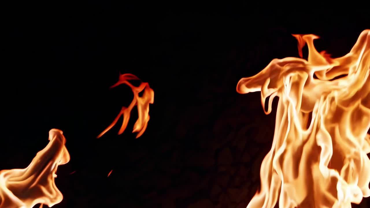 Dynamic close-up video of swirling flames against a dark background, capturing the fluid motion