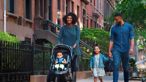 young black family with stroller walking in brooklyn street