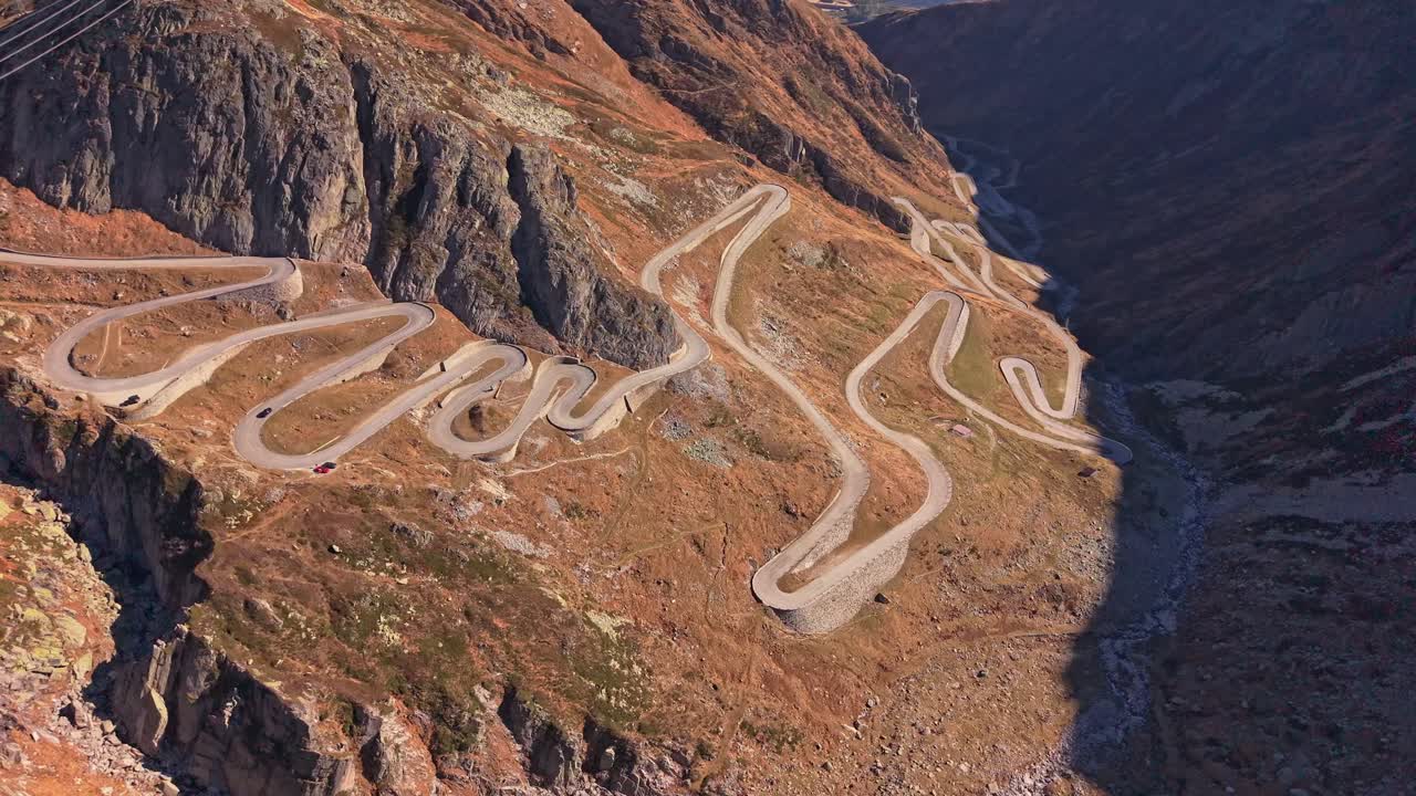 Winding Tremola Road curves through Swiss Alps, aerial perspective
