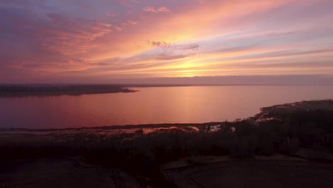 lake burtnieks in late autumn red sky sunset aerial wide view wit tree silhouette