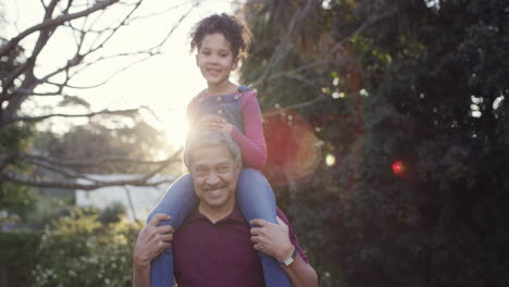 cheerful senior man carrying his granddaughter