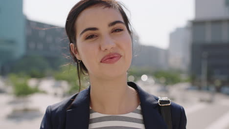 portrait of beautiful middle eastern woman intern looking at camera smiling cheerful running hand through hair in sunny urban background