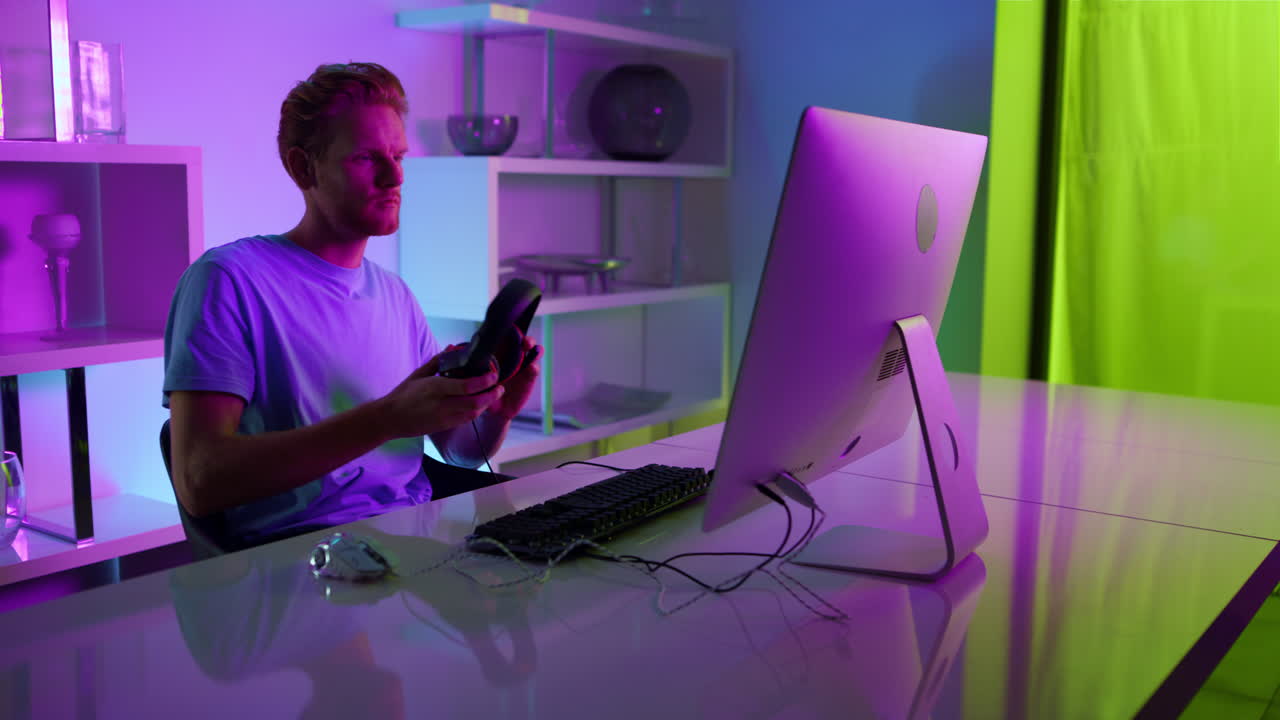 Gamer che indossa le cuffie giocando a un videogioco a casa. Interno con luci al neon.
