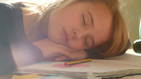 chica cansada durmiendo con la cabeza acostada en la tarea