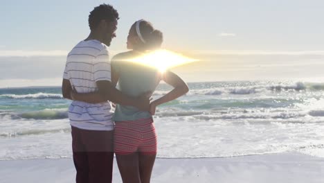 Animation-of-light-trails-over-african-american-couple-at-beach