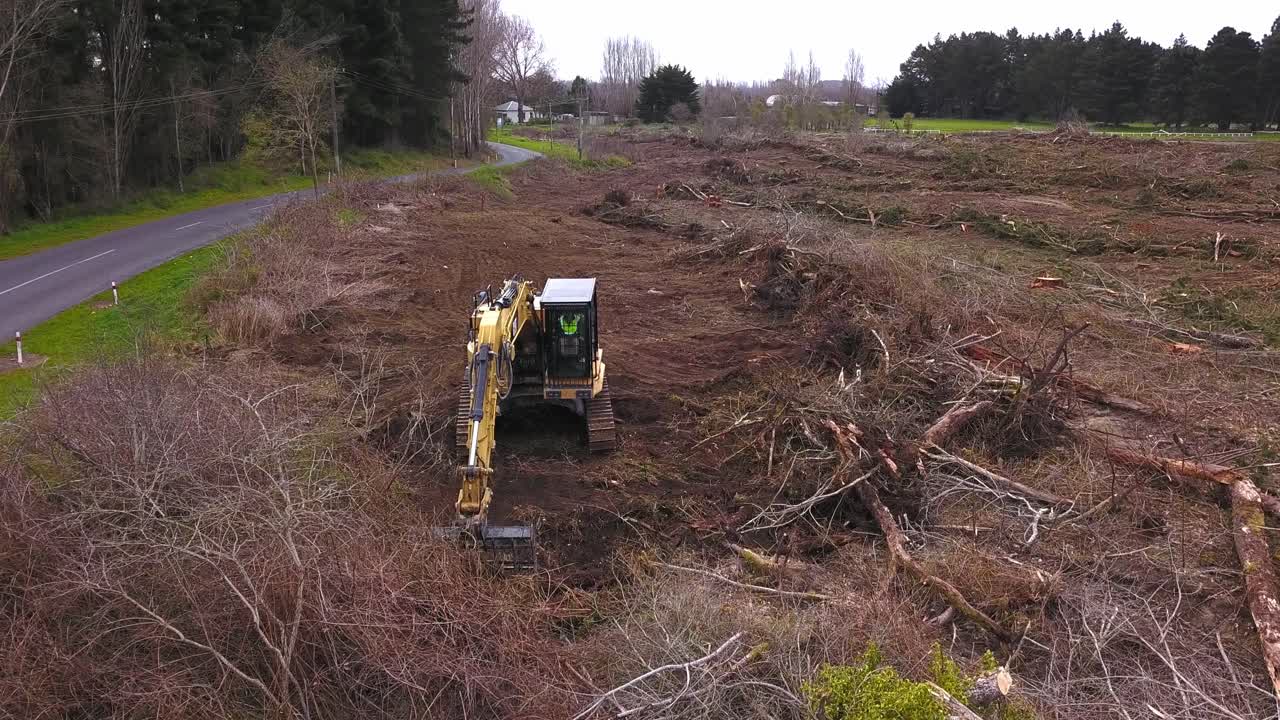 Forest Roadside Cleanup: Digger Clearing Debris from Logging Operations