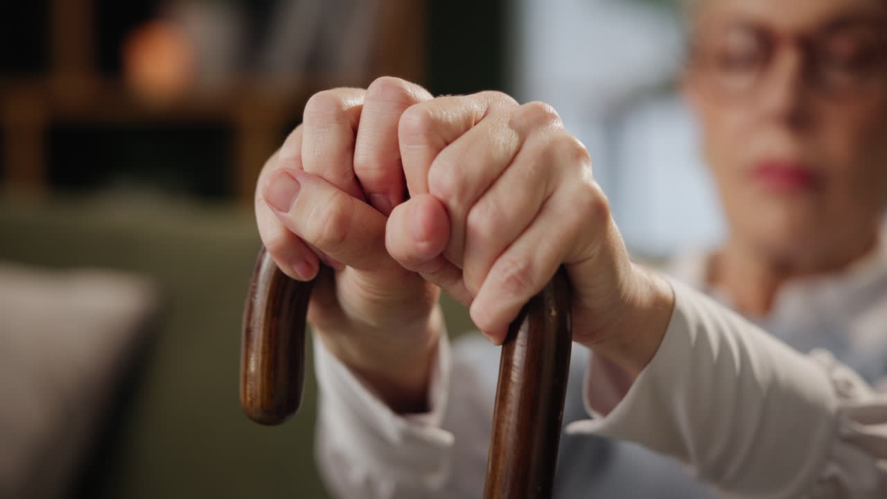 Senior woman's hands holding a walking cane
