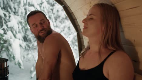 caucasian adult couple enjoying in the sauna in winter.