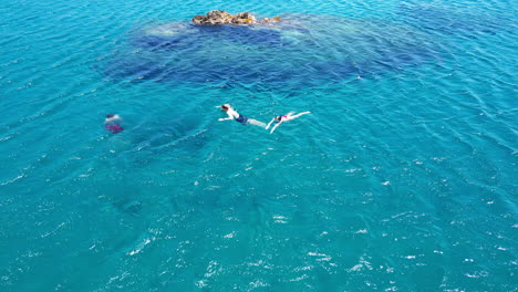 aerial view of young tourists swimming around a