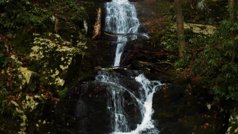 photographer hiker setting up tripod to take pictures of waterfall