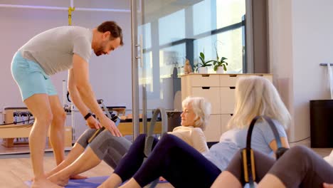 entrenador ayudando a las mujeres mayores en la realización de yoga 4k