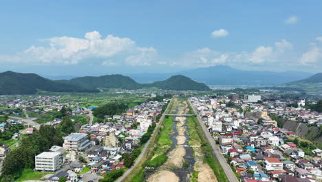 aerial ascending tilt shot of the yamanochi town, sunny, summer day in japan