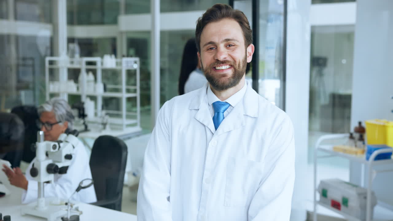 Sonriente científico en bata de laboratorio de pie en un laboratorio moderno
