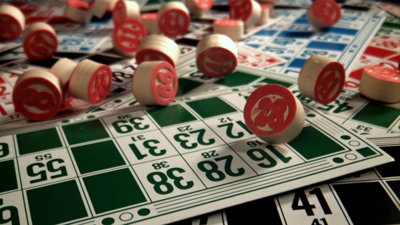 Primo piano di segnalini da bingo rossi e bianchi che cadono su cartelle da gioco