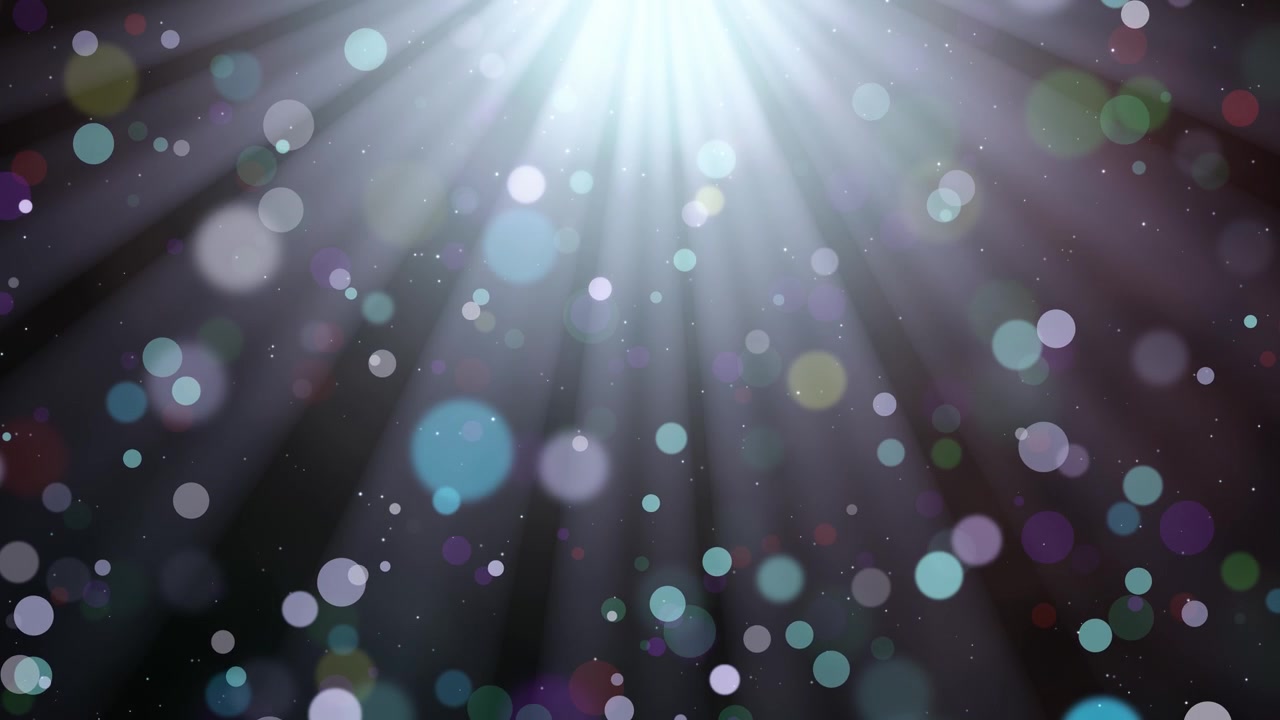 Bright light rays illuminate a cascade of colorful, soft-focus bokeh particles, loopable magical and festive abstract background animation
