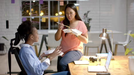 young african american woman shares a business meal with a biracial woman at the office