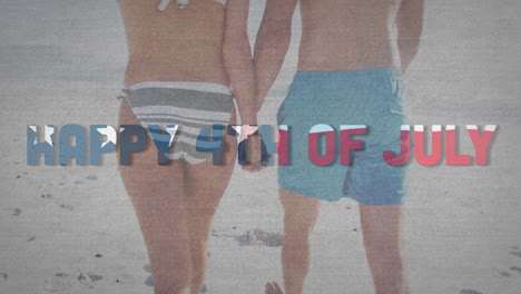 texto del día de la independencia contra la sección media de una pareja caucásica cogida de la mano y caminando por la playa