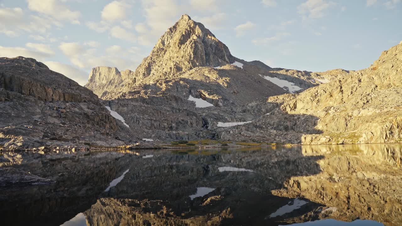 Bjergenes spejling på en stille alpesø ved solnedgang langs John Muir Trail