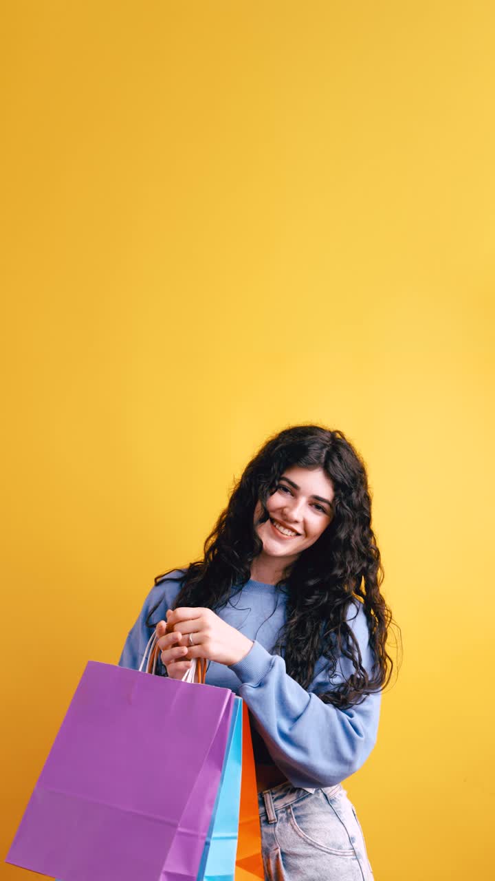 Woman with Shopping Bags on Yellow Background
