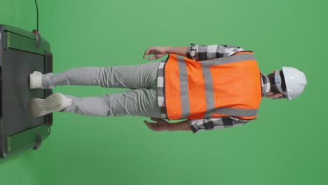 back view of full body asian male engineer with safety helmet looking around while walking in the green screen background studio