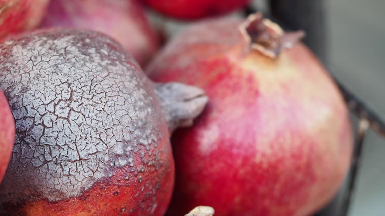 Close-up of a pile of pomegranates, showing the textured skin of one in focus