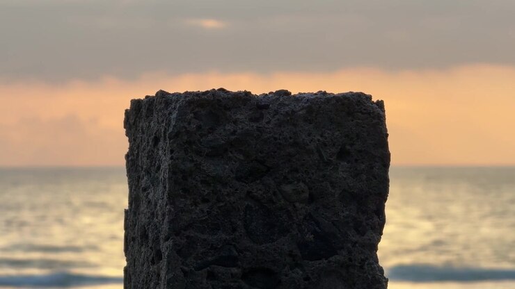 Concrete Pillar Standing Against a Blurred Ocean Sunset