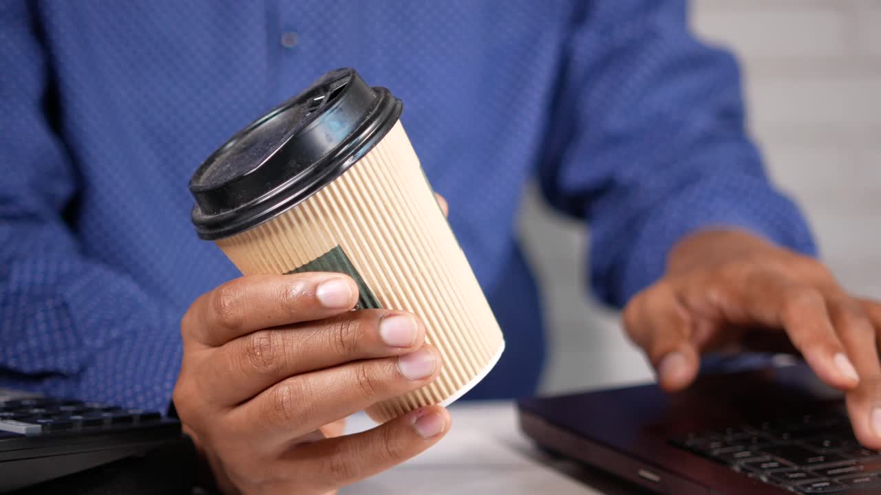 persona trabajando en una computadora portátil con café