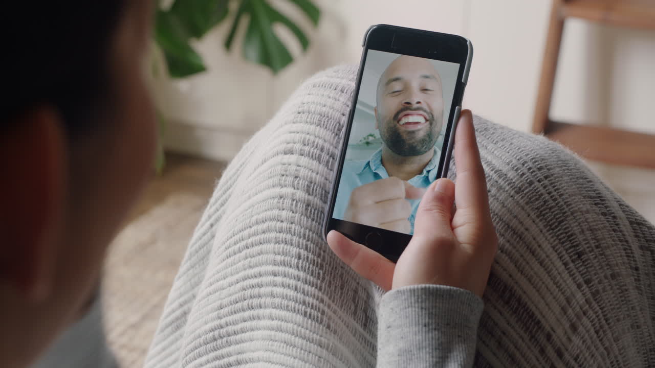 mujer joven usando un teléfono inteligente teniendo video chat con su novio sordo comunicándose usando lenguaje de señas gestos con las manos disfrutando de la comunicación en línea