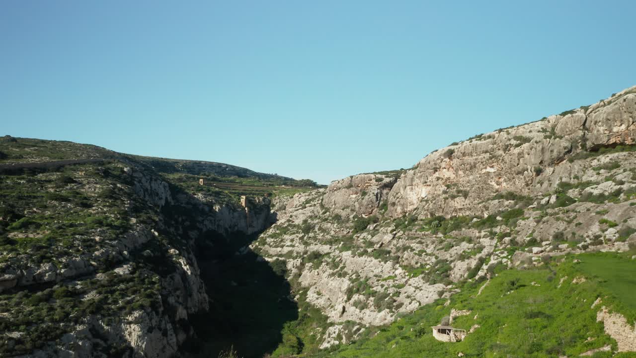 AEREA: Vista panoramica del canyon della baia di Magrr Ix-Xini con vegetazione che cresce su ripide colline