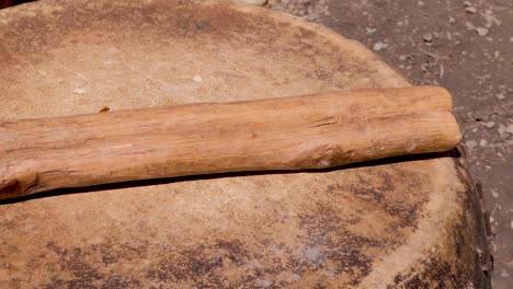 traditional wooden drumsticks and a large hide drum on a tropical island in timor leste, south east asia