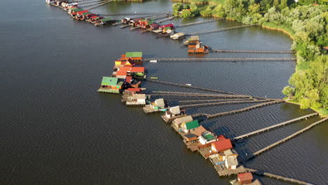 bokodi-hutoto lake with small stilt village over it in hungary, aerial drone shot