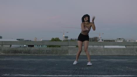 Mujer-Bailando-Atractiva-Bailarina-Callejera-Hispana-En-La-Ciudad-Realizando-Movimientos-Contemporáneos-De-Hip-Hop-Disfrutando-De-La-Expresión-De-Danza-Moderna-Al-Atardecer