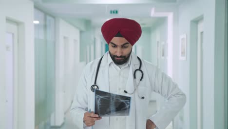 stressed sikh indian doctor checking x ray report