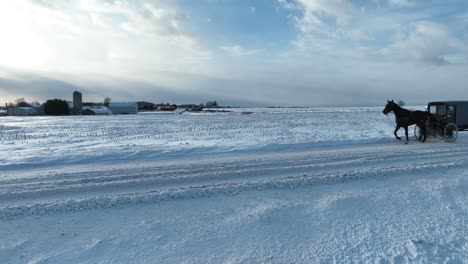 Amish-horse-and-buggy-passing-on-snow-covered-road-in-rural-USA-countryside-in-winter